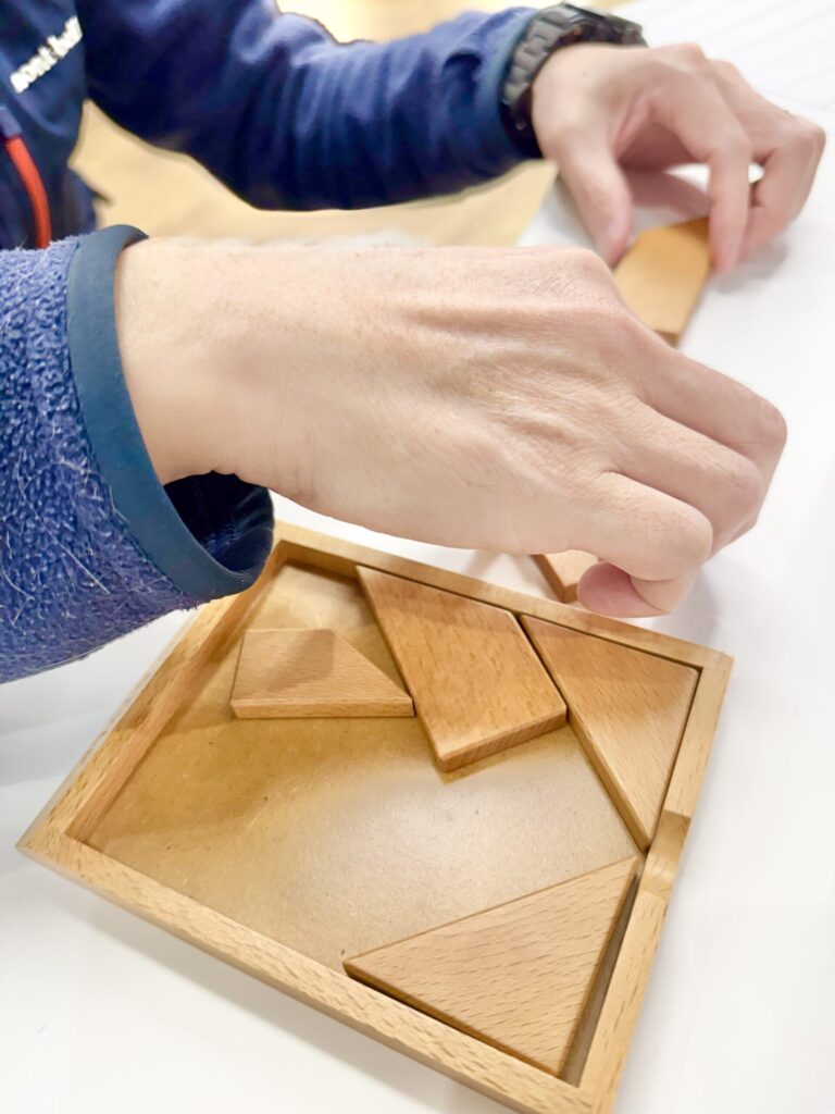 指示を聞いてパズルを組み立てる様子